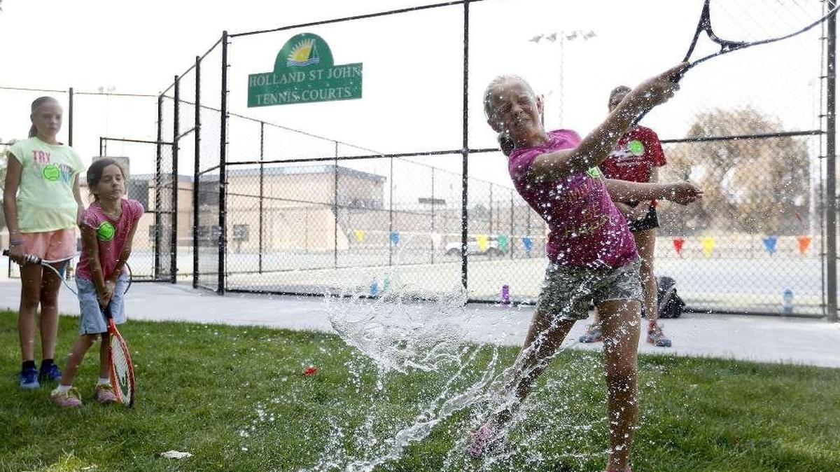 
Hailey Summers, 9, works on her forehand tennis stroke in August by hitting a water balloon at the Holland St John Tennis Courts in Richland.

