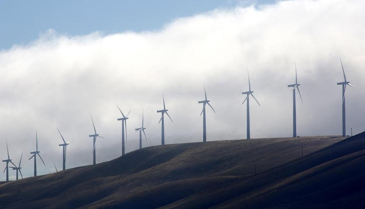 Clouds create a dramatic backdrop for the spinning wind turbines south of Kennewick.
