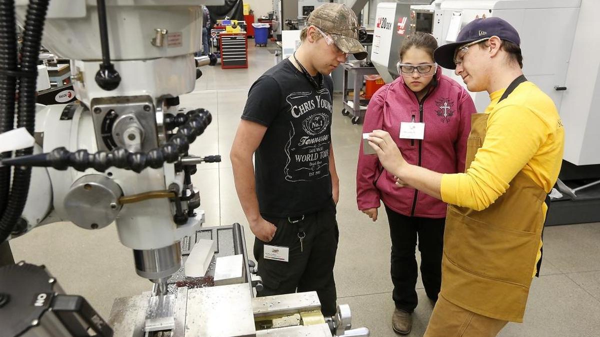 Southridge senior Kolby Salter, left, and Richland junior Ashleigh Hurst, middle, pay attention Friday as CBC student Seth Gorham explains the use of a vertical milling machine during the second annual Careers in Manufacturing workshop at the Pasco campus. Watch a video at tricityherald.com/video
