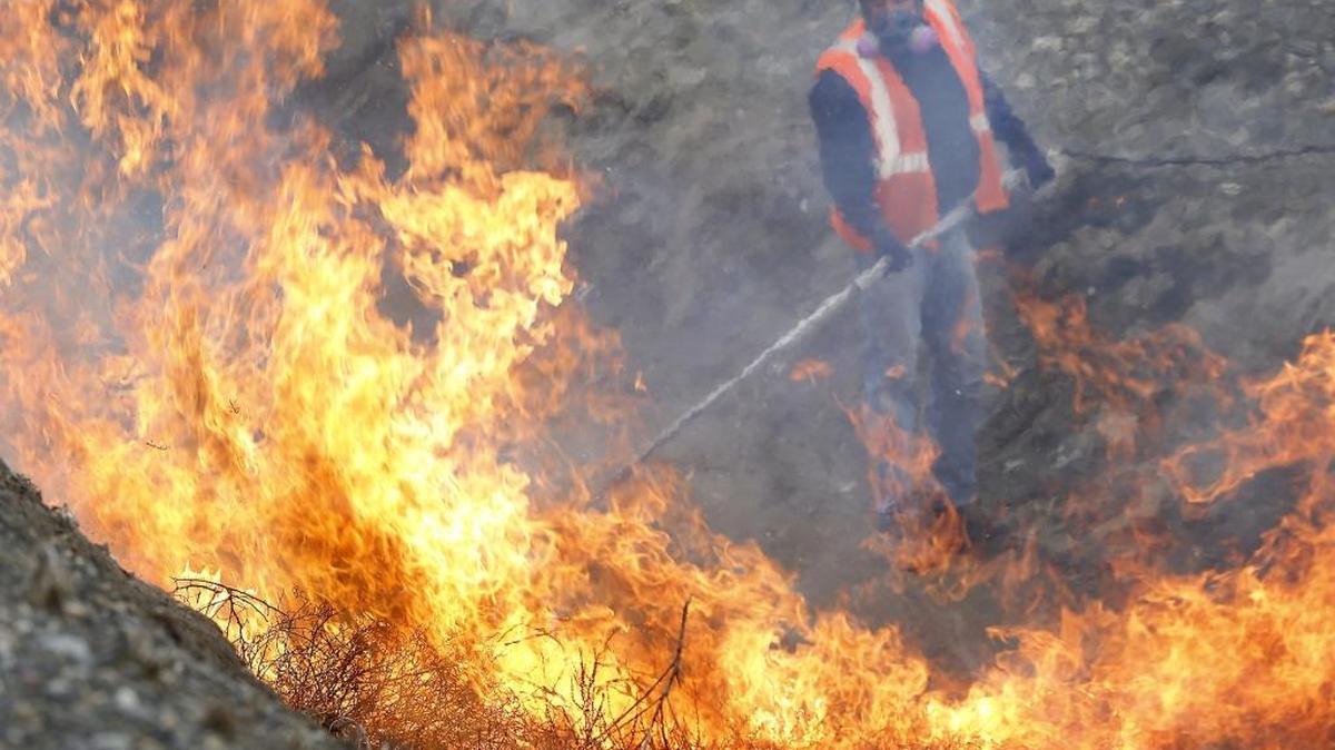 Paulino Nafarrate, an employee of Columbia Irrigation District, aims a propane torch Monday at a pile of tumbleweeds filling the district’s canal off East 10th Avenue near the Benton County Fairgrounds in Kennewick. The workers are busy cleaning out the agency’s canals before they are primed with water March 20 for the start of this year’s irrigation season.