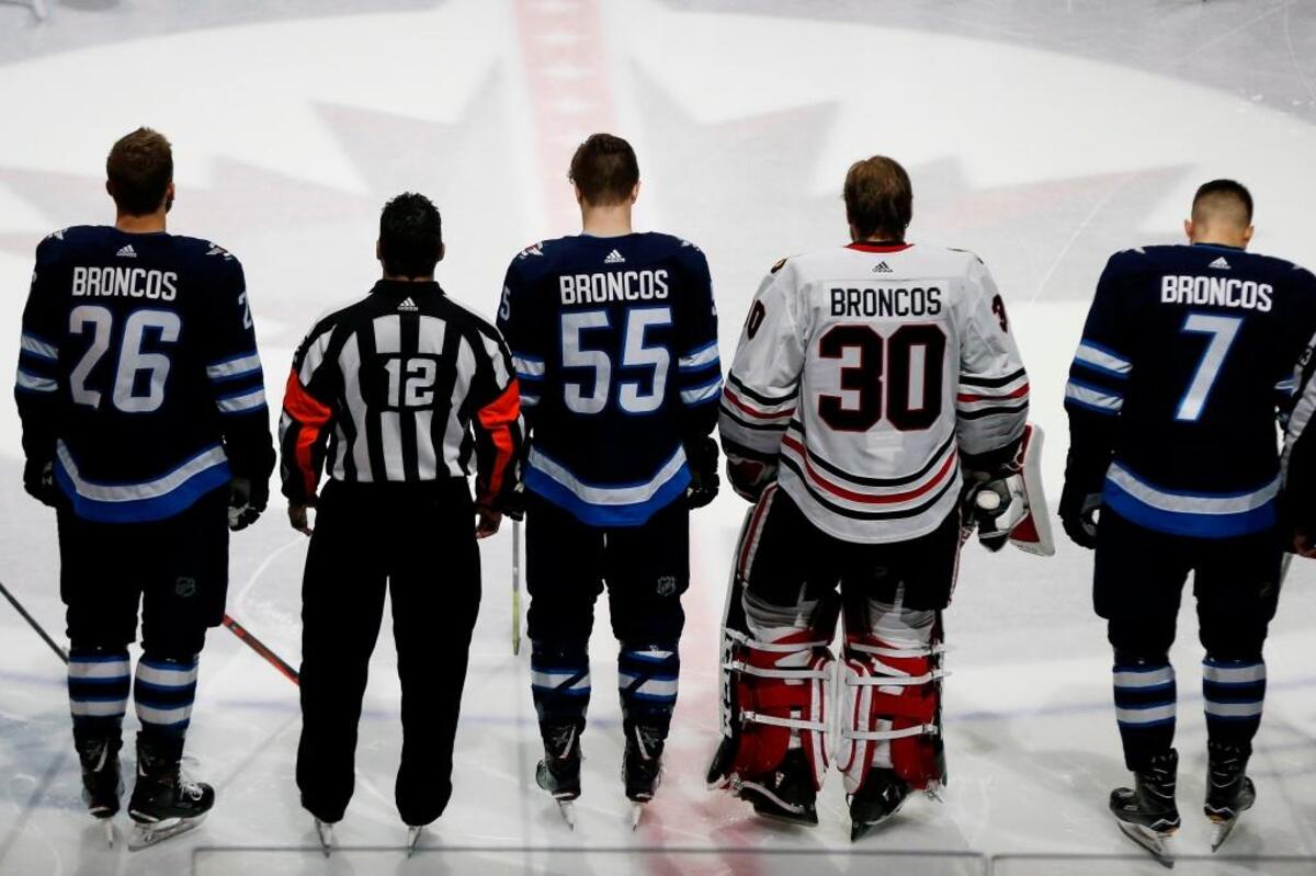 The Winnipeg Jets and the Chicago Blackhawks come together at center ice Saturday wearing Broncos on the back of their jerseys for a moment of silence for the Humboldt Broncos bus crash victims before their game in Winnipeg, Manitoba.