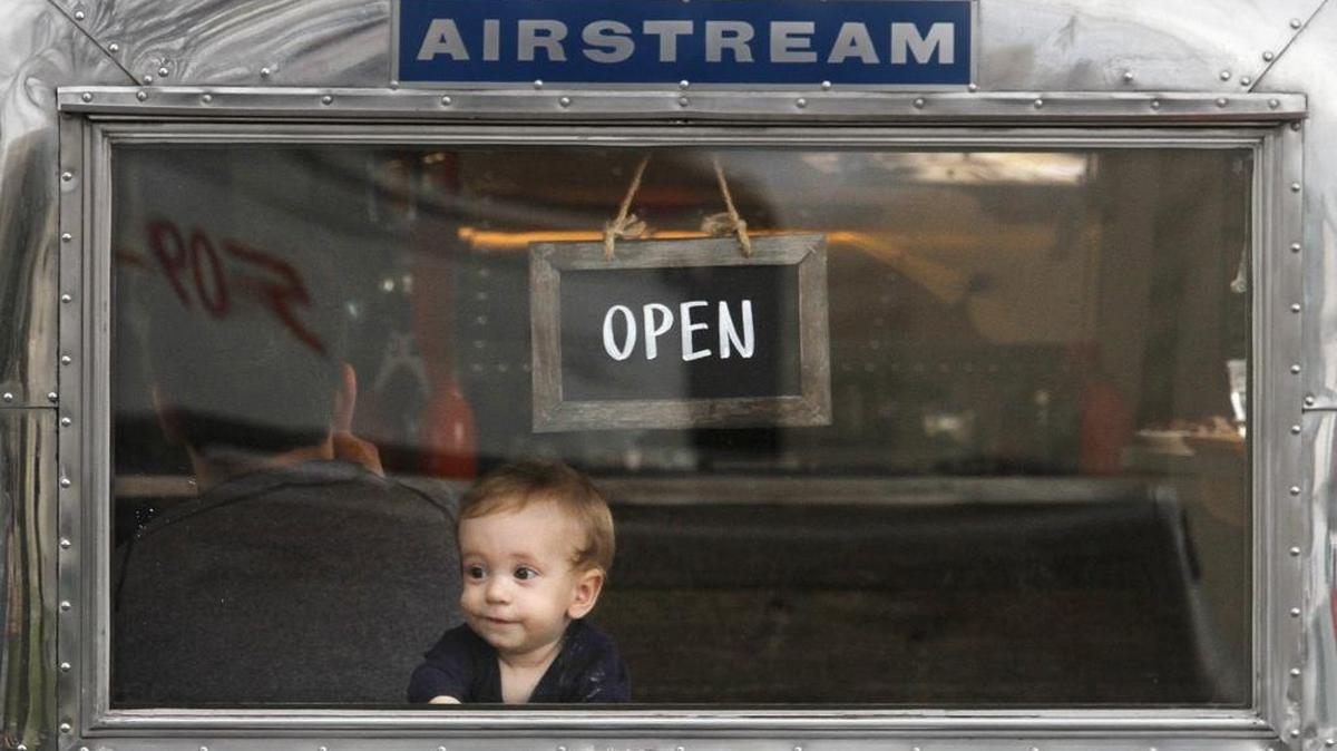 Henry Arthur-Durett looks out the window of the Ström Coffee Airstream trailer in John Dam Plaza in Richland while his dad James Durett, of Richland, enjoys a cup of coffee in this file photo. It is closing.