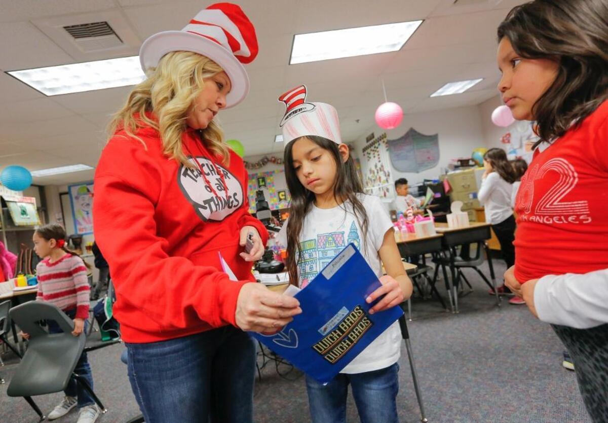 Kris Mars, a third-grade teacher at Hawthrone Elementary School in Kennewick, answers questions from Nicole Carcamos and Kylee Cullooyah at the end of class.