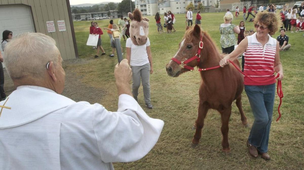 
Tina Daily of Kennewick keeps a tight grip on the lead for her 30-year-old horse named Ricky as Father Richard Sedlacek officiates at Friday’s 29th annual Blessing of the Pets ceremony at St. Joseph’s Catholic School in Kennewick. The annual event honors the Feast Day of Saint Francis of Assisi. Eighth-grade student Meredeth Martin follows Daily wearing the school’s mascot costume of Diego the Mustang. Pet owners will have an opportunity at 4 p.m. Oct. 4 to participate in another pet blessing ceremony at All Saints Episcopal Church in Richland. For more information call 943-1169.
