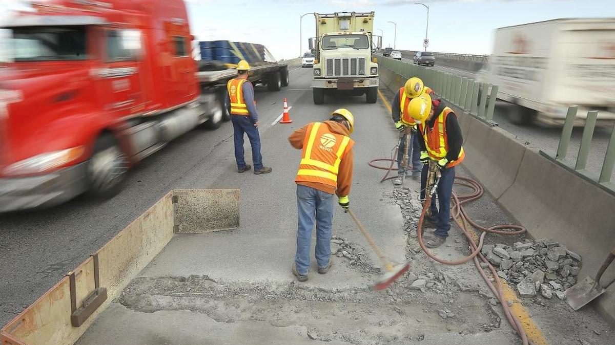 Traffic moving across the blue bridge passes within feet of Washington State Department of Transportation workers making emergency repairs Thursday on the decking on the Kennewick side of the span across the Columbia River. Motorists are restricted to one southbound lane and the Lewis Street on-ramp in Pasco was closed to traffic for the day-long project. They are fixing potholes, repairing the green glare screens and performing other maintenance.