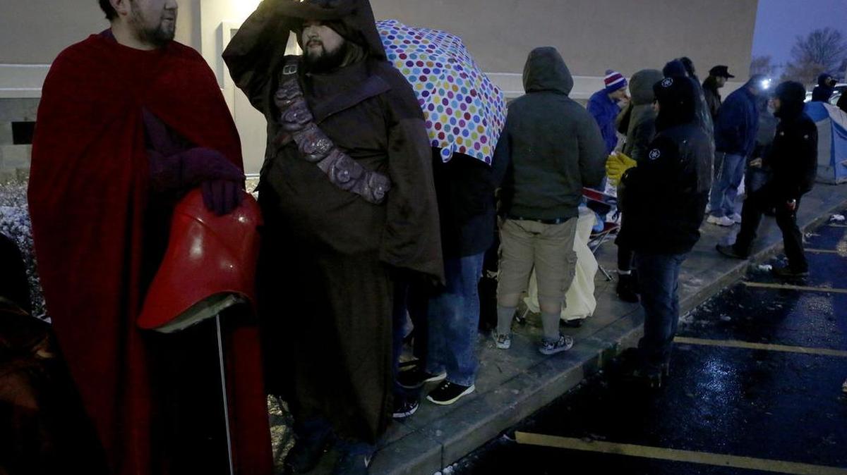 Manuel Diaz of Kennewick, left, dressed as a member of the Emperor’s Royal Guard, and his brother Louis, dressed as a Jawa, wait in line at Fairchild Cinemas in Pasco on Thursday to see Star Wars: The Force Awakens. The brothers, who bought their movie tickets after the first trailer came out, arrived at 1:30 p.m. to wait with friends for the 7 p.m. showing of the movie. See a video at www.tricityherald.com