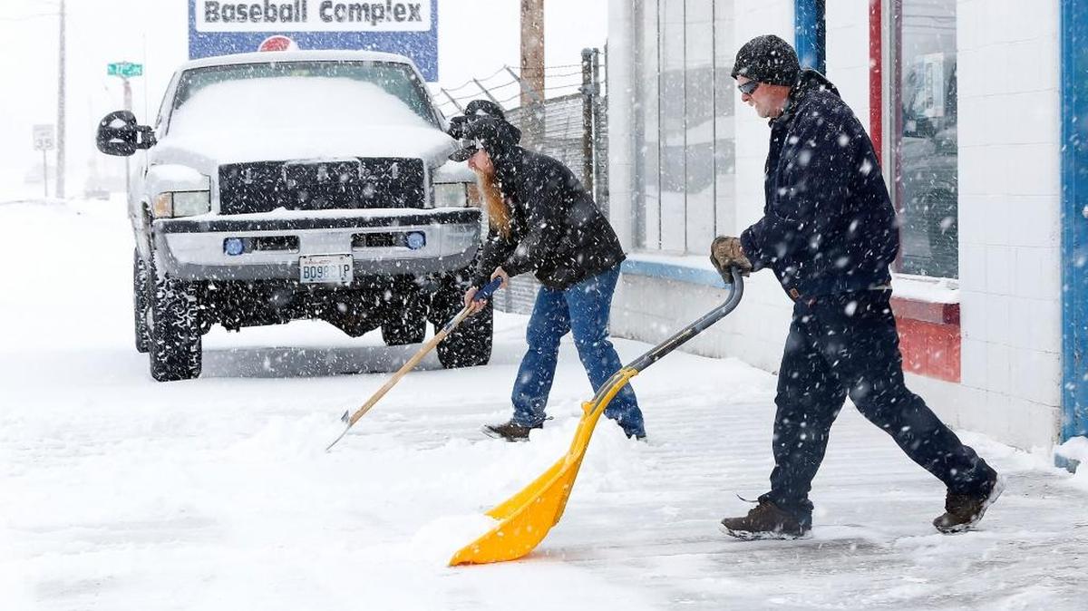 Jason Koontz, left, and Randy Knight work in tandem last February shoveling snow from in front of their businesses on West A Street in Pasco. About 15 inches of snow fell that month.