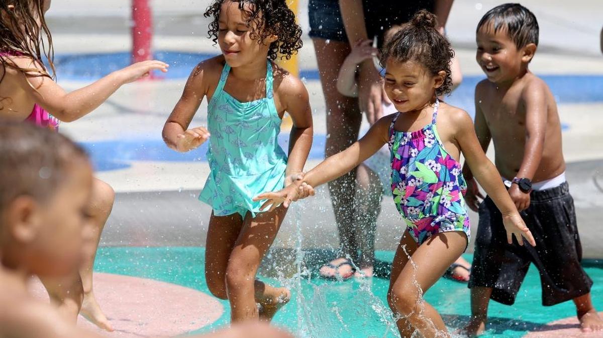 Baysha Bodden, 4, of Kennewick, left, holds hands with her sister Shylah, 2, as they run through the spray park Wednesday at Columbia Park in Kennewick. High temperatures through June 3 should be in the mid-80s to 90 degrees, June 4 will see a high in the upper 90s and Sunday could reach triple digits. The city of Kennewick’s aquatic playgrounds are open every day from 11 a.m. to 7 p.m., Richland’s are open from 10 a.m. to 8 p.m. daily and Pasco’s are open 11 a.m. to 7 p.m. daily.