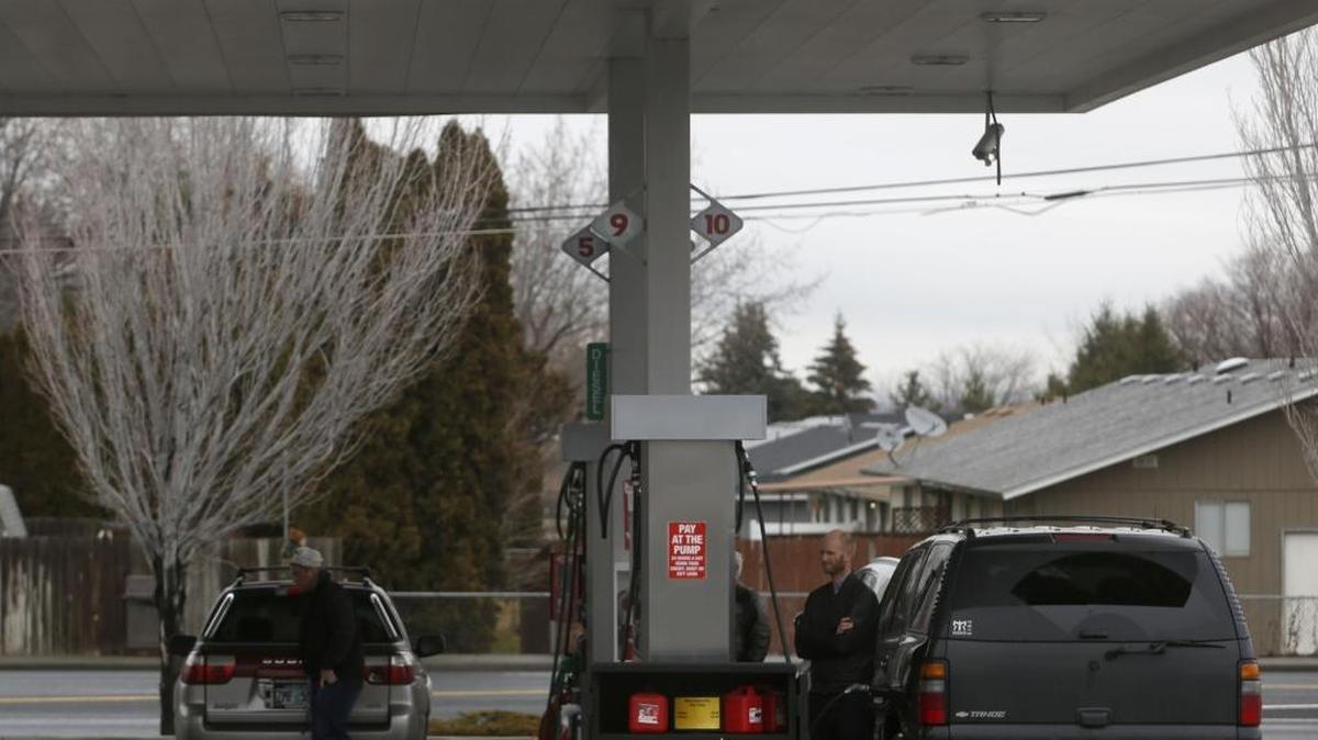 Joe Ansingh, right, of Kennewick, fills up his car Thursday at the Fred Meyer Fuel Center on 10th Avenue in Kennewick. Gas prices have fallen below $2 at some gas stations in the Tri-Cities, lower than the state average but higher than the national average.