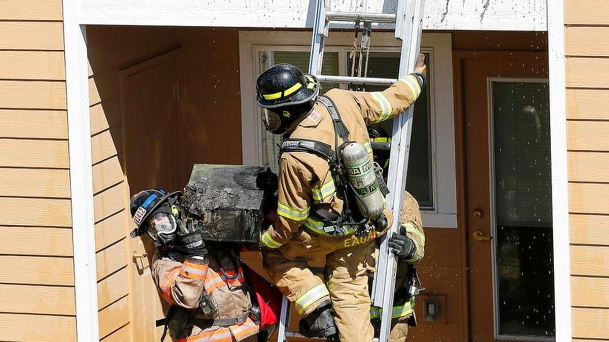 Firefighters from Benton County Fire District 4 haul away charred items from the patio of a second-floor patio at the Quail Springs Apartments in 2016. The department is looking to voters to approve a $7.5 million bond to add a station in their growing district.