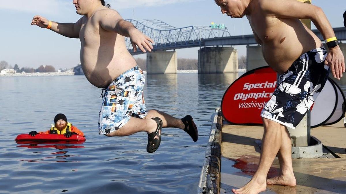 Special Olympics athletes Anthony Nash, left, and Mark Berger jump into the Columbia River Saturday as they participate in the Polar Plunge Tri-Cities in Kennewick. See a video at tricityherald.com/video