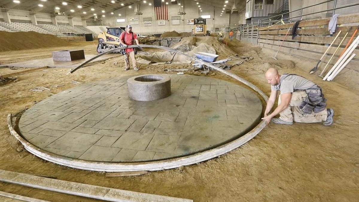 Abraham Martinez, left, and David Huber, both employees of All Season Contractors of Pasco, work Monday to remove the form from a custom-decorated concrete patio for their company’s display at the 2016 Regional Tri-Cities Home and Garden Show at TRAC in Pasco. The three-day show starts Feb. 19. Admission is $6 for adults, free for 12 and under. There is a $1 discount for donation of a non-perishable food item for Salvation Army.