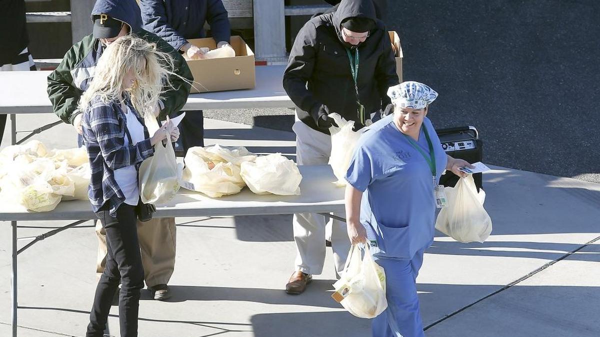 Trios employee Jessica Crosby flashes a smile after receiving free Thanksgiving turkeys Friday afternoon from the executive team and hospital board commissioners at the Trio Southridge Hospital.