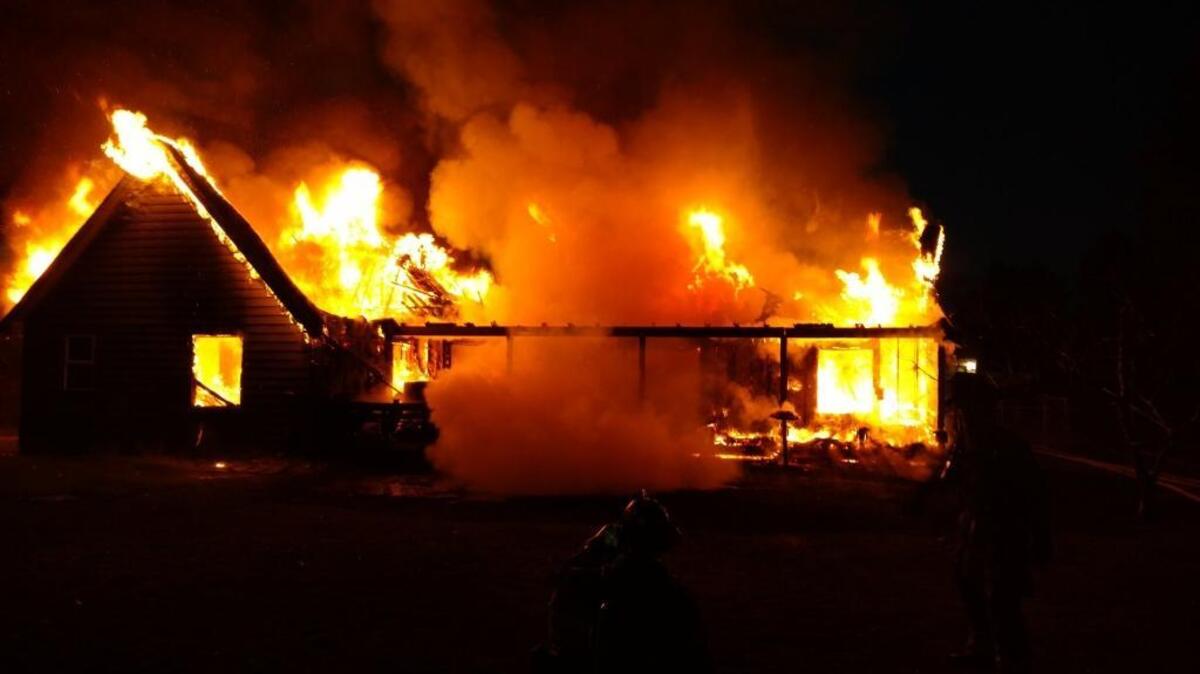 A home on West Richardson Road in Pasco’s Riverview neighborhood is a total loss following a fire that apparently began with a heat lamp in a doghouse. Above the rear of the home burns Sunday morning.