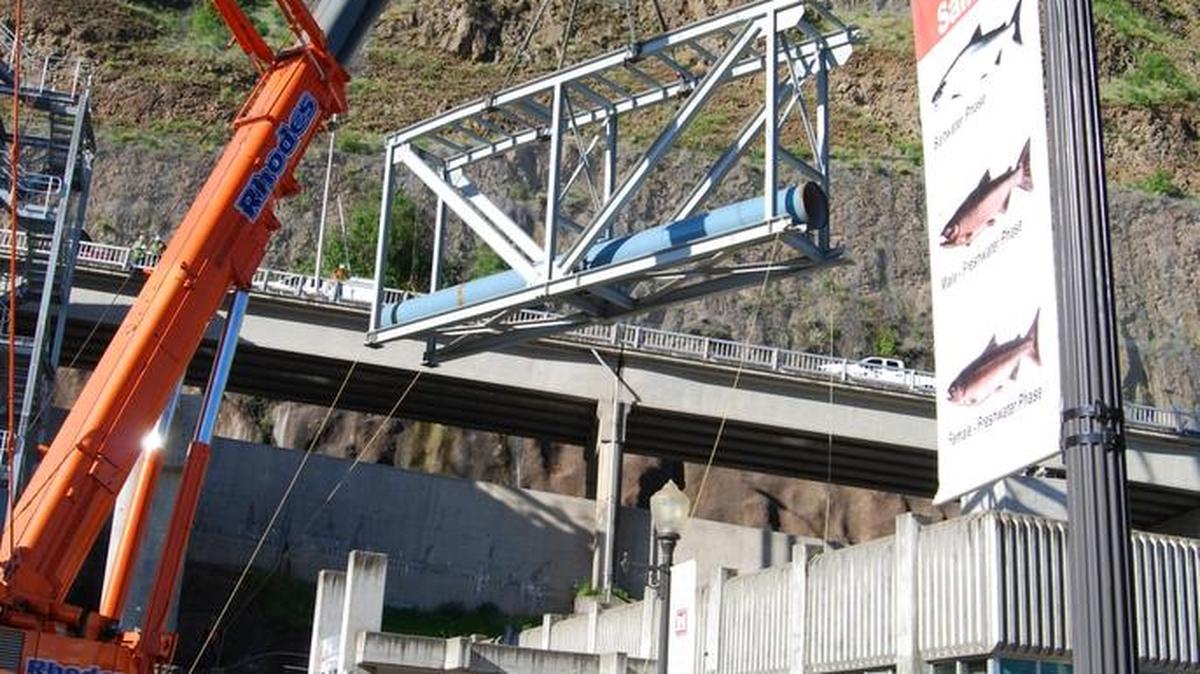 A crane is used to hoist a load over the top of Lower Granite Dam’s visitor center and adult fish ladder as construction progresses on a new fish bypass system.