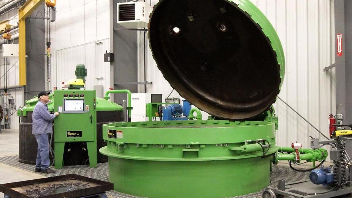 Bill Ervin, an employee of Timken Power Systems, operates the controls to the cover of a 10-foot diameter vacuum pressure vessel in the new motor and gearbox repair facility in Pasco. A recent $7 million expansion allows the company to rebuild electric motors up to 5,000 horsepower.