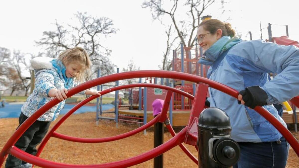 Abby Gallaher, 3, left, holds onto a teeter totter as her mother, Sarah, of West Richland, bounces her at Howard Amon Park in Richland on Wednesday morning. The National Weather Services said Thursday also will be cloudy with rain likely in the morning.