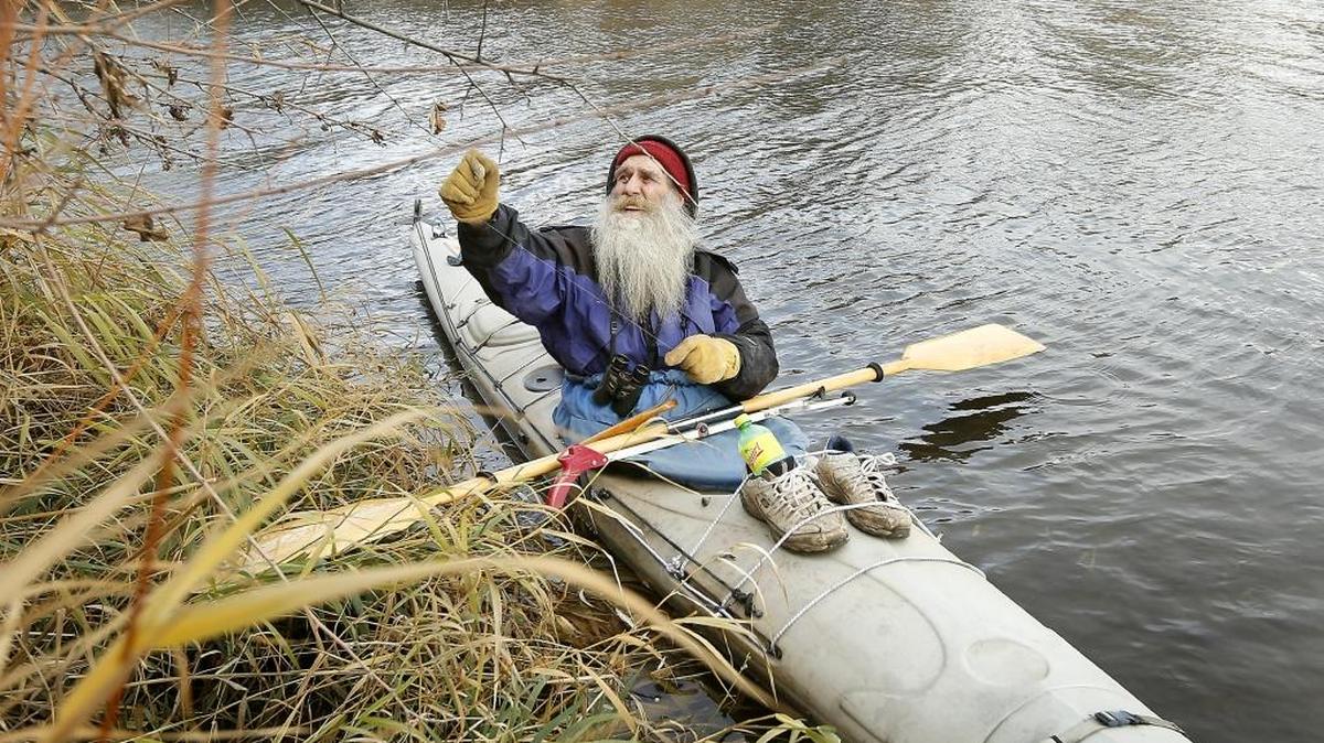Kayaker Jay Scott pulls tangled fishing line from a shoreline tree Wednesday while paddling around the Hood Park Boat Basin in Burbank. The Pendleton resident said he regularly collects and disposes of fishing line during his kayaking trips because he once discovered a tangled up Osprey that had drowned. He also spent time bird watching with his binoculars during his outing.