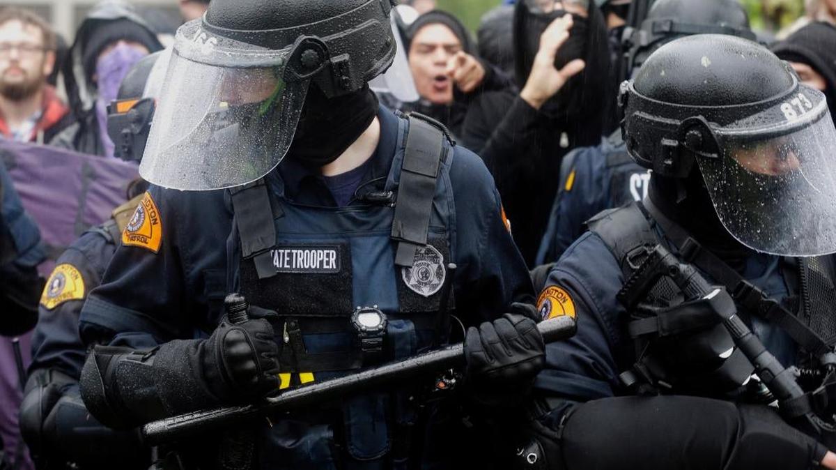 Washington state troopers try to keep counter-protesters back from a protest by the conservative group Patriot Prayer at Evergreen State College in Olympia.
