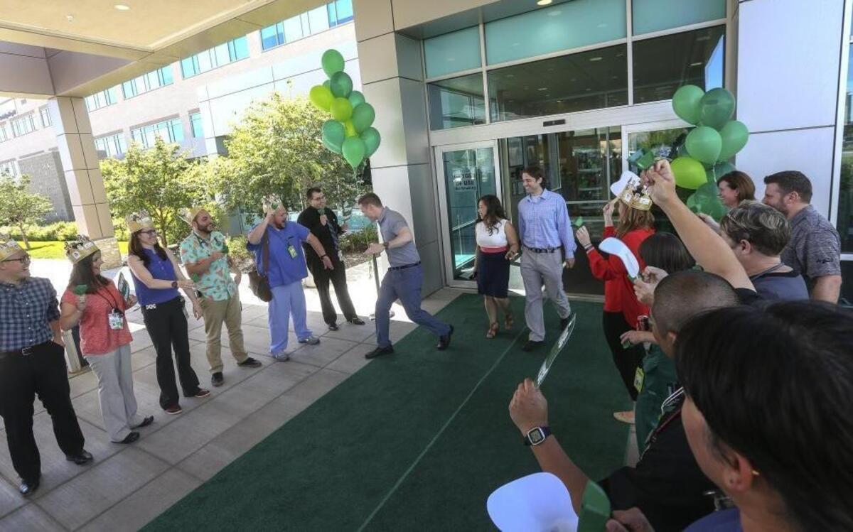 Trios Health employees cheer for Drs. Jeff McDannel, Jazzlyn Gallardo and Scott McDonald as they walk out of Trios Southridge Hospital in Kennewick on Friday. The three physicians are part of Trios’ latest graduating class of medical residents. McDannel, 31, an Arizona native, is staying in the Tri-Cities to practice medicine.