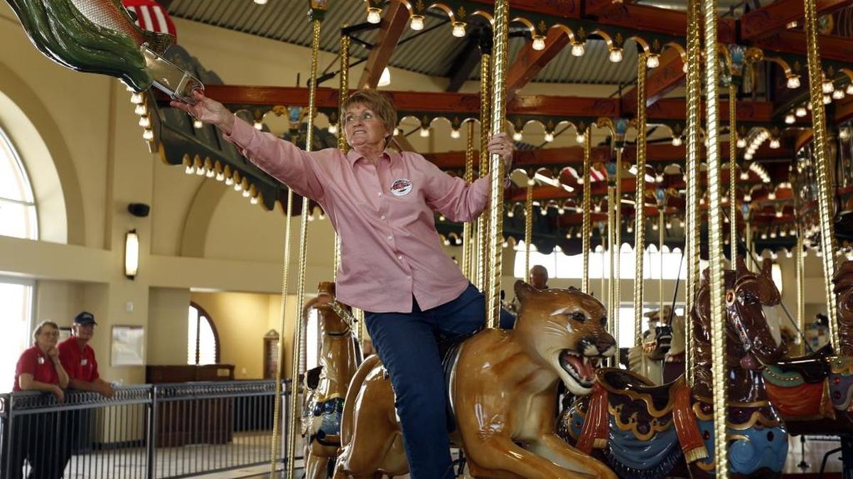 
Barbara J. Straight of Kennewick reaches to grab a ring while riding the Gesa Carousel of Dreams last week at the Southridge Sports and Events Complex in Kennewick.
