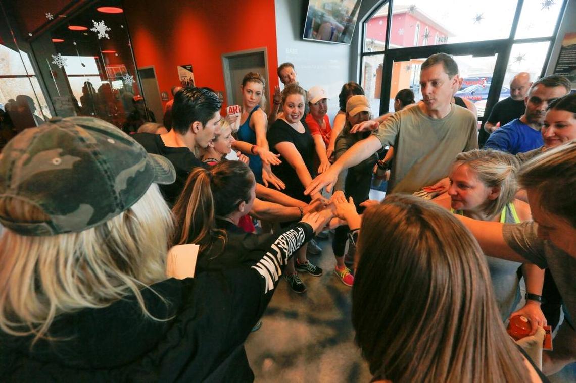 Gym members and staff from OrangeTheory goes hands in before cheering "Cassi," before taking part in a fundraising workout class on Saturday, Jan. 13 in Richland at OrangeTheory. The fundraiser was done in secret to surprise Cassi Juell with a new prosthetic leg.