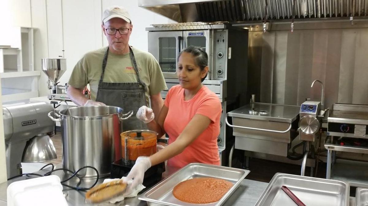 David Stenoien and Kavita Patel-Stenoien prepare a base for their curry sauce at Pasco Specialty Kitchen. The West Richland couple launched Fast & Curryous, a food truck selling curries and kebabs, in May.