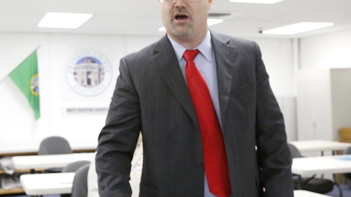 Franklin County Auditor Matt Beaton flips a quarter and Robert Hagans called it over a cellphone during Tuesday’s manual recount for the Kahlotus City Council position after they tied with 19 votes each. Hagans was declared the winner over Marcia Robitaille.