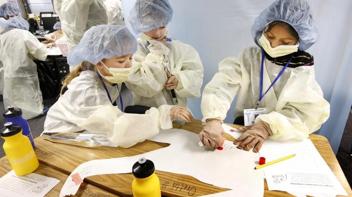 Oretta Fryer, Lincoln Bachelder and Ruby Velasquez, from left, “operate” on a compound sentence in Heather Huisingh’s second-grade dual-language class at Hawthorne Elementary School in Kennewick. Huisingh started the fun lesson on sentence structure last year. Kadlec Regional Medical Center in Richland donated their surgical wardrobe. Watch a video at: tricityherald.com/video.