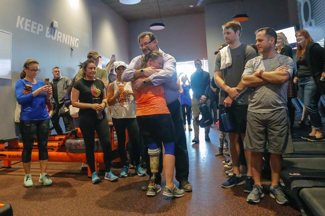 Friends, family and OrangeTheory team members watch as Cassi Juell hugs Chris Boosalis, Cassi’s original Minnesota prosthetist on Saturday in Richland.
