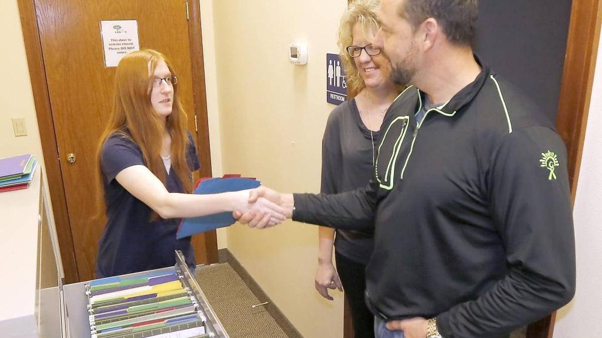 Samantha Burns of Kennewick shakes hands Thursday with Olie Kolzig, former Tri-City American and NHL goaltender, during his visit to the Responding to Autism Center in Kennewick. Burns is a client at the organization that recently received a grant from the Carson Kolzig Foundation. Christine Lindgren, center, director of the Responding to Autism Center, introduces the two.