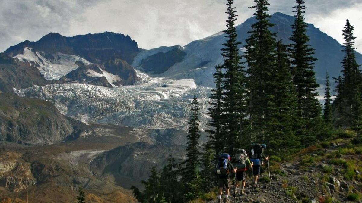 Mount Rainier looms while hiking toward the Tahoma Glacier on the west side. Permits for the 93-mile Wonderland Trail in Mount Rainier National Park are on sale.