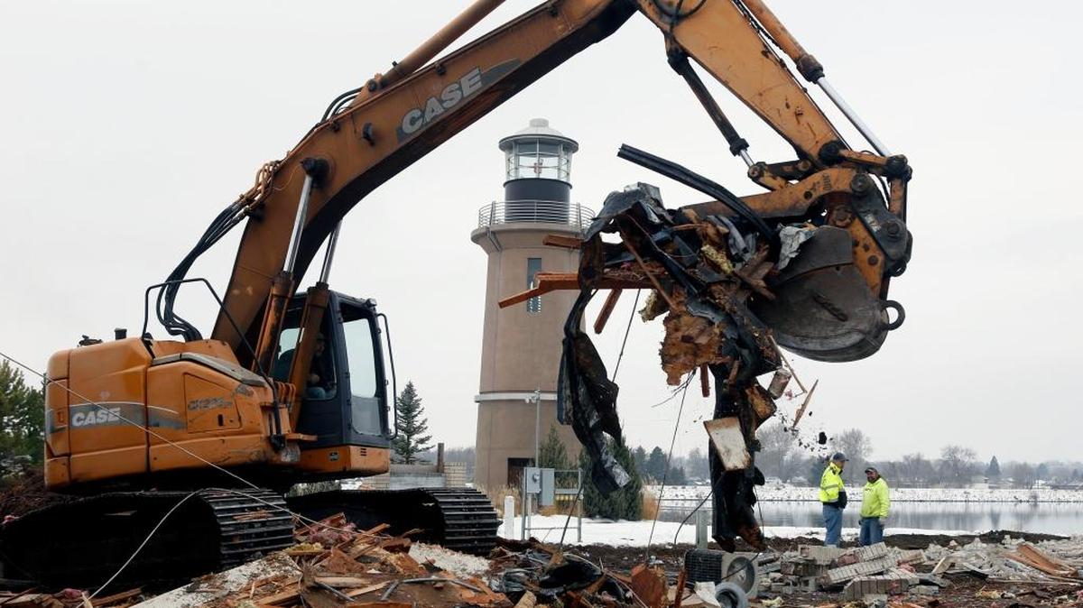 An excavator with Big D’s Construction lifts rubble from a pile of debris Thursday while demolishing the Port of Kennewick’s former office building on Clover Island. The building is being removed so the Army Corps of Engineers can restore the shoreline and extend the public trail, as well as allow for future development. The work is part of a joint ecosystem restoration project between the Corps and the port.