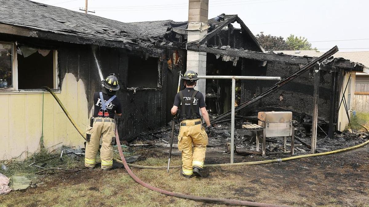 Pasco firefighters mop up hot spots on the back side of a house at 1753 N. 22nd Ave. Thursday afternoon in Pasco. Fire officials say no one was home when the blaze broke out. The cause is under investigation. Watch a video at tricityherald.com/video.