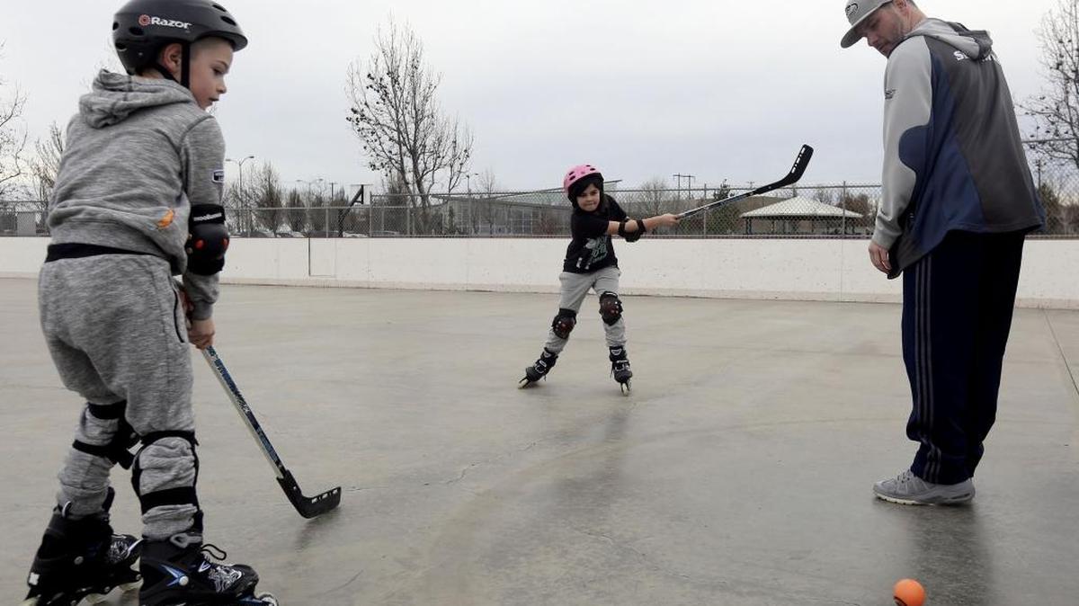 Amil Bowen, 9, of Kennewick, center, and her brother Julian, 7, left, look on as their dad Jessie blocks a shot while playing playing roller hockey at the rink at Highlands Grange Park in Kennewick. According to the National Weather Service, the area saw a high of 67 on Saturday. The weather will continue with a high of 60 on Sunday with a chance of showers.