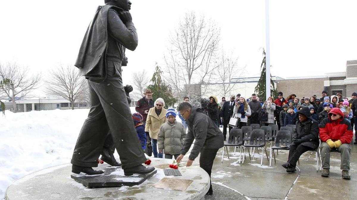 Jayden Williams, 8, left, and his cousin Deonte Muse, 14, place roses Monday at the Martin Luther King Jr. statue as part of the 26th annual bell-ringing ceremony at Columbia Basin College in Pasco. About 180 people attended the event which started with a brief ceremony outside at the statue and then moved inside for the formal presentation of the Martin Luther King Jr. Spirit Award to Kennewick Fire Chief Vincent Beasley.