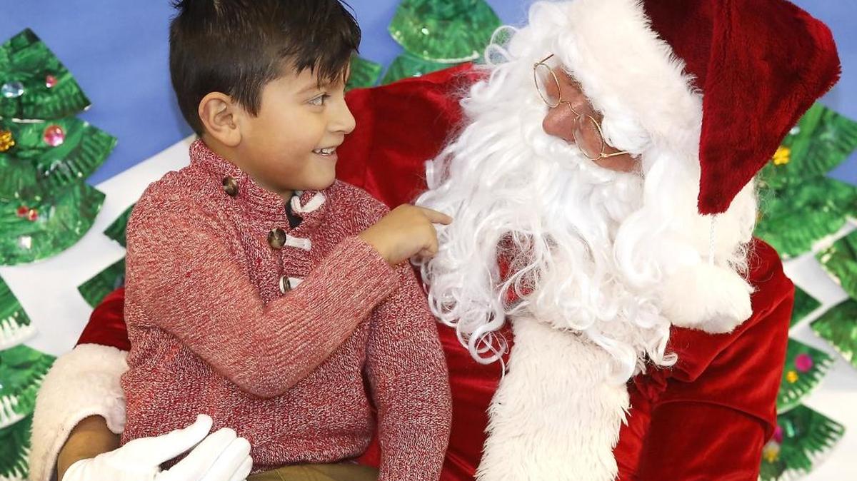 Head Start student Irving Chavez wears a big grin Thursday morning during his talk with Santa Claus at the annual Energy Northwest Holiday Party at the Pasco preschool facility. Employees of Energy Northwest donated Christmas gifts to 440 local children and presented them at 11 parties this year. It's the 37th year for the distributions and more than 12,000 children of low-income families have received gifts since 1980. Energy Northwest employee Heath Ovens portrays Santa's helper. Watch a video at tricityherald.com/video
