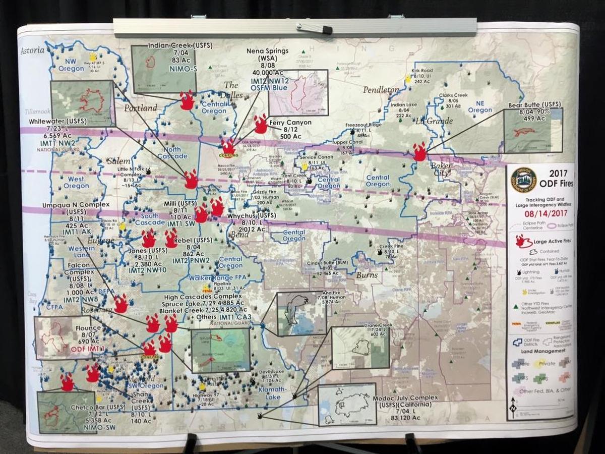 A map shows wildfires burning in Oregon and the path of the eclipse coming Aug. 21.