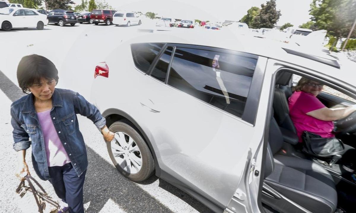Gregoria Maguigad, left, gets out of Bonnie Causey’s car as she arrives to the Tri-Cities Cancer Center in Kennewick.
