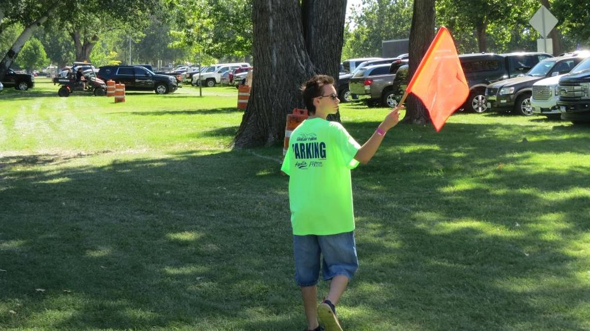 A Kennewick student volunteer leads traffic into a parking spot Sunday morning at the Tri-City Water Follies
