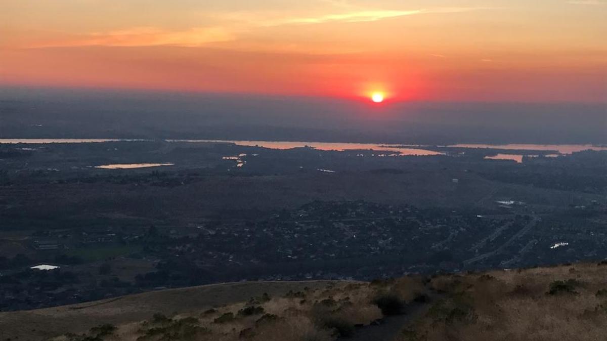 Hikers on Badger Mountain in Richland saw a the sun rise Friday morning through a thick band of smoke around the Mid-Columbia.