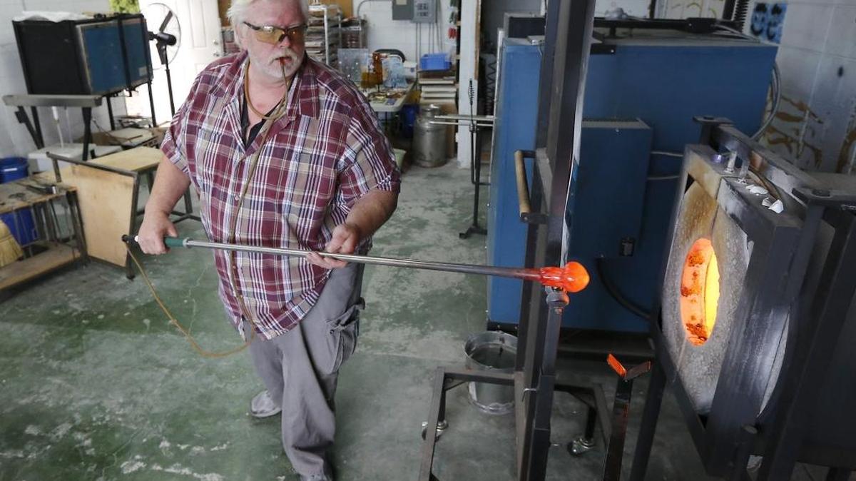 Earl Wright, owner of The Glass Punty, reheats a glob of molten glass while using a traditional glass-blowing technique to create a colorful Christmas ornament in his tiny Richland shop at 288 Williams Blvd. See a video at tricityherald.com/video