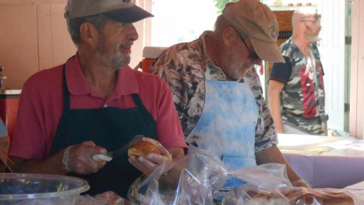 Volunteers dish up salmon at a popular food booth run by Columbia Basin Fly Casters and the Richland Rod and Gun Club during Art in the Park at Richland’s Howard Amon Park.