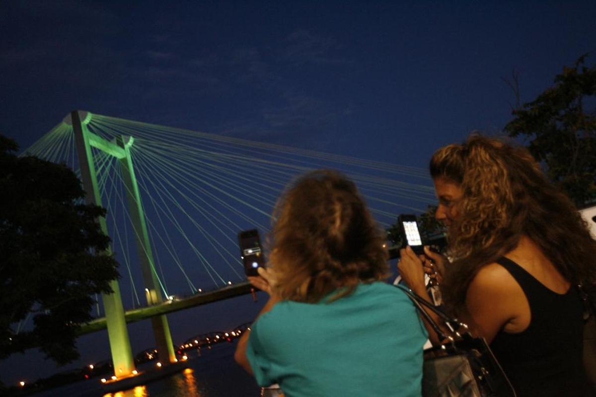 About 100 people gathered at the Clover Island Inn in Kennewick in August 2013 to watch the cable bridge turn teal to raise awareness of ovarian cancer throughout September.