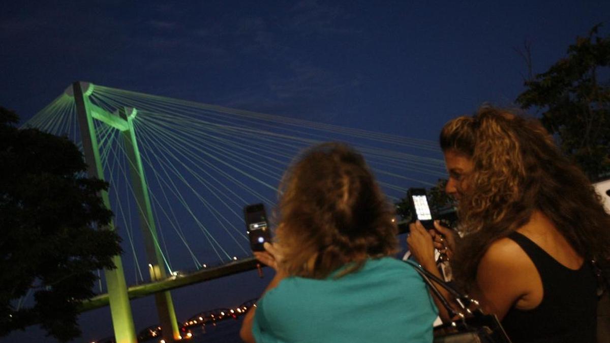 
About 100 people gathered at the Clover Island Inn in Kennewick on Thursday, Aug. 29, 2013, to watch the cable bridge turn teal to raise awareness of ovarian cancer throughout September. 
