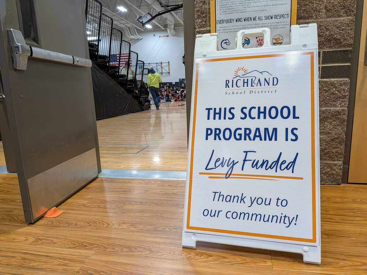 A sandwich sign outside a wrestling match at the Leona Libby Middle School gymnasium in Richland thanks taxpayers for their support to fund extracurricular activities.