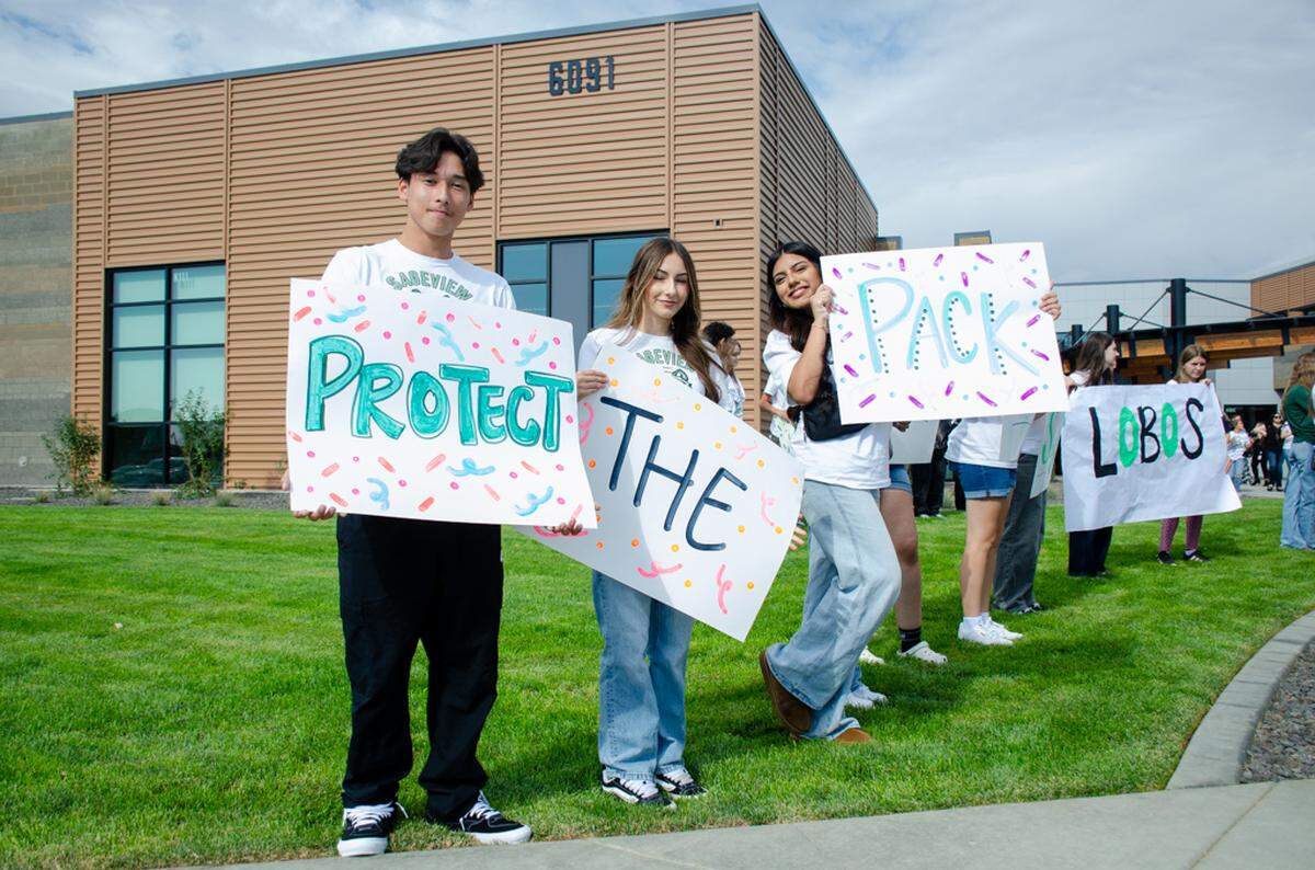 New Sageview High School students hold up signs with their school mantra, “Protect the Pack,” at a ribbon cutting ceremony on Monday, Aug. 18. Hundreds of people showed up to see the brand new Tri-Cities school, located at 6091 Burns Road.