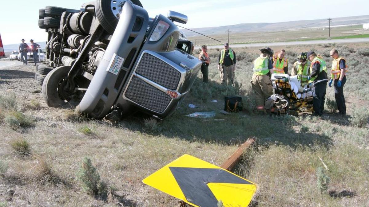 Emergency workers from Benton Fire District 4 rescue a driver who rolled his semi-truck on Interstate 82 near West Richland in 2014.