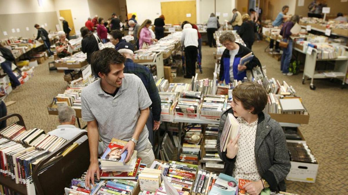 Zack Zappone, left, of Richland, and Sarah Munger of Kahlotus look over books for sale at the Mid-Columbia Libraries branch on Union Street in Kennewick.