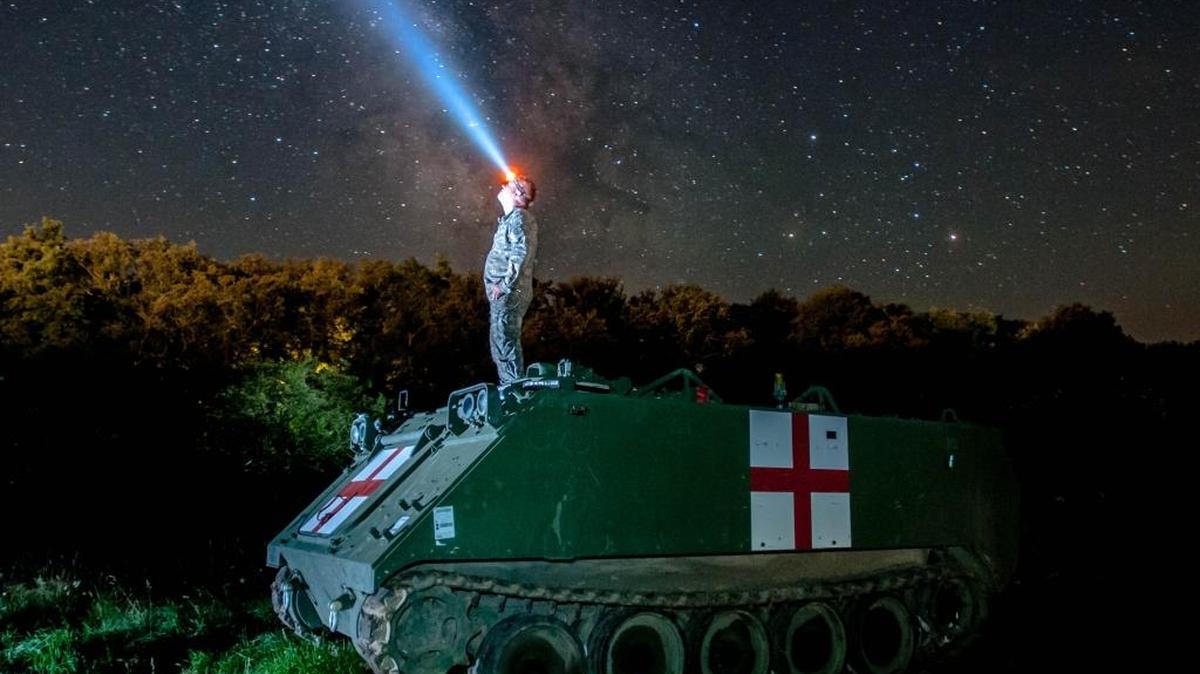 Staff Sgt. Brad Foster, a combat medic with Headquarters and Headquarters Company, 3rd Battalion, 116th Cavalry Brigade Combat Team out of Pendleton, watches the night sky on top of an M113 medical evacuation vehicle during Exercise Saber Guardian 16 at the Romanian Land Forces Combat Training Center in Cincu, Romania.